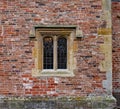 Old ornate concrete window with stained glass in a weathered brick wall in an old manor house Royalty Free Stock Photo