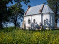 Old orthodox church surrounded by green trees and yellow flowers in the foreground Royalty Free Stock Photo