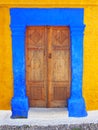 Ottoman style ornate wooden door double in a bright blue painted stone frame set in a yellow wall in rhodes town greece Royalty Free Stock Photo