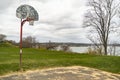 Old outdoor baskeball hoop with the broken wooden backboard in a park in Portland Maine.