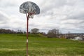 Old outdoor baskeball hoop with the broken wooden backboard in a park in Portland Maine.
