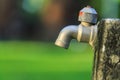 Old outdoor faucet without water in garden on green blur background Royalty Free Stock Photo