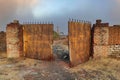 The old outer wall and broken iron gate of an abandoned factory Royalty Free Stock Photo