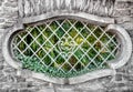 Old oval window with iron bars. Royalty Free Stock Photo