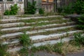 Old overgrown with destroyed stone balustrades old antique steps of a stone staircase. Ruined stairs. The dilapidated building, Royalty Free Stock Photo