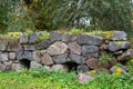 Old overgrown rock wall with forged loops as reinforcement Royalty Free Stock Photo