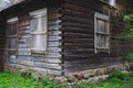 Old overgrown wooden house with a stone foundation built in traditional style in Lithuania Royalty Free Stock Photo