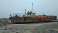 An old ownerless ship rusting in the arctic tundra on the shores of the Barents Sea. Varandey