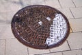 An old oxidized telephone manhole on a public walkaway