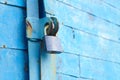 old padlock on a blue metal door with wooden planks cracked paint and rust Royalty Free Stock Photo