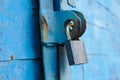 old padlock on a blue metal door with wooden planks cracked paint and rust Royalty Free Stock Photo