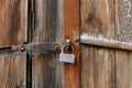 Old padlock on gates. A rusty lock hangs on the wooden door Royalty Free Stock Photo