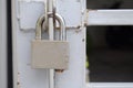 Old padlock hanging on gray metal door