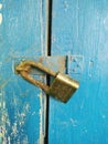 An old padlock that locks a dark blue door Royalty Free Stock Photo