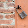 Old padlock on metal door. Red brick wall Royalty Free Stock Photo