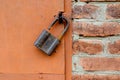 Old padlock on metal door. Red brick wall Royalty Free Stock Photo