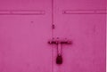 Old padlock on metal gate in pink color. Royalty Free Stock Photo