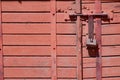 Old padlock on rustic red wooden door Royalty Free Stock Photo