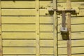 Old padlock on rustic yellow wooden door Royalty Free Stock Photo