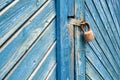 Old padlock on a weathered retro blue wooden door. Textured background. Royalty Free Stock Photo