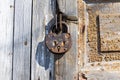 Old Padlock On A Wooden Door. Heavy Granary Iron Lock