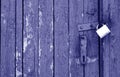 Old padlock on wooden gate in blue tone Royalty Free Stock Photo