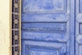 Old painted blue door of weathered wood and ceramic tiles on an old plaster wall in Spain Royalty Free Stock Photo