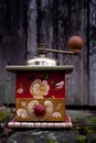 Old painted coffee grinder outsdie in front of weathered wooden door Royalty Free Stock Photo