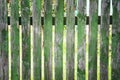 Old painted green wooden fence, peeling paint Royalty Free Stock Photo