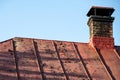 Old painted metal roof. Peeling paint and an old brick chimney Royalty Free Stock Photo