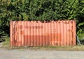 Old orange coloured container, left in the countryside, by some trees in, Wilsden, Yorkshire, UK Royalty Free Stock Photo