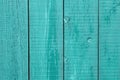 Old painted turquoise wooden fence. Cracked wood timber, blue shabby planks, green flaky grunge background. Oak table. Rustic weat Royalty Free Stock Photo