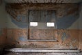 Old painted wall in abandoned building with small windows Royalty Free Stock Photo