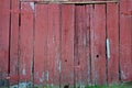 An old red painted weathered barn with a double door for background