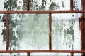 Old painted window behind rusty grate Royalty Free Stock Photo