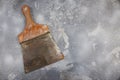 Old painter`s spatula with rust and use marks with wooden handle on cement background Royalty Free Stock Photo