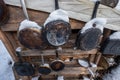 Old pans in burnt ash hanging on wall. A warm looking cottage at the middle of a snowy winter forest. Firewood stacked Royalty Free Stock Photo