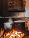 Old pans simmering on a rustic fireplace