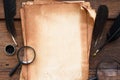 Old paper on brown wood texture with feather and ink, magnifying glass Royalty Free Stock Photo