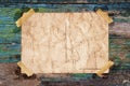 Old paper postcard stopped with adhesive tape on a grunge wood texture Royalty Free Stock Photo