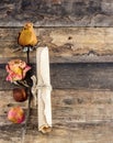 Old paper roll and dry rose on a wooden background Royalty Free Stock Photo