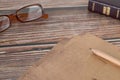 Old paper sheets on wooden table with eyeglasses, pencil, and a closed holy Bible Book Royalty Free Stock Photo