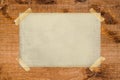 Old paper stopped with adhesive tape on a grunge wood texture Royalty Free Stock Photo