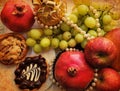 Old paper texture with gorgeous ripe sweet fruit and cream cakes. Red apples, pomegranates and green grapes. Edible gift