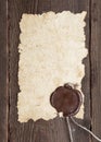 Old paper with a wax seal on brown wood texture Royalty Free Stock Photo