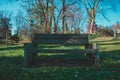 An Old Park Bench in a Shady Field With Trees Behind It Royalty Free Stock Photo