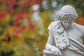 Old park statue of Renaissance Era Roman man hunter in lion skin with hunting tube in golden Autumn city park, Potsdam, Germany Royalty Free Stock Photo