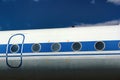 Old passenger aircraft door and windows against blue sky background Royalty Free Stock Photo