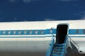 Old passenger aircraft door and windows against blue sky background