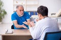 Old male patient visiting young male doctor Royalty Free Stock Photo